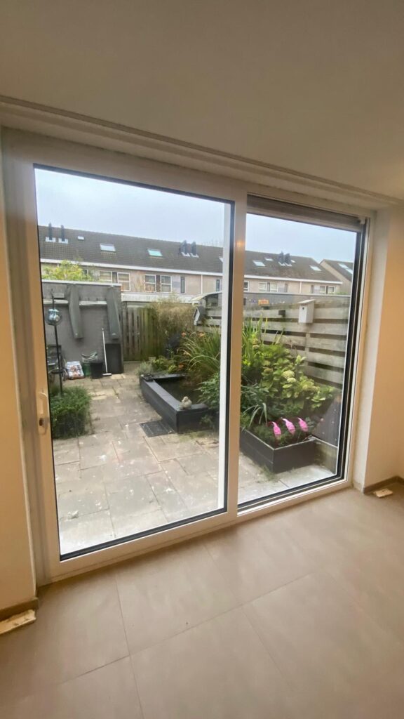 Binnenaanzicht aluminium schuifpui met ruim zicht op de tuin in Capelle aan den IJssel