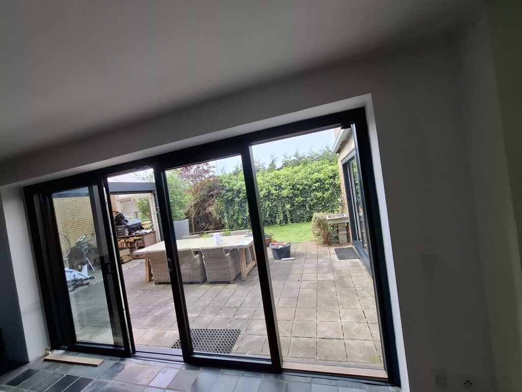 Uitzicht door de 4 meter brede aluminium schuifpui naar de tuin.