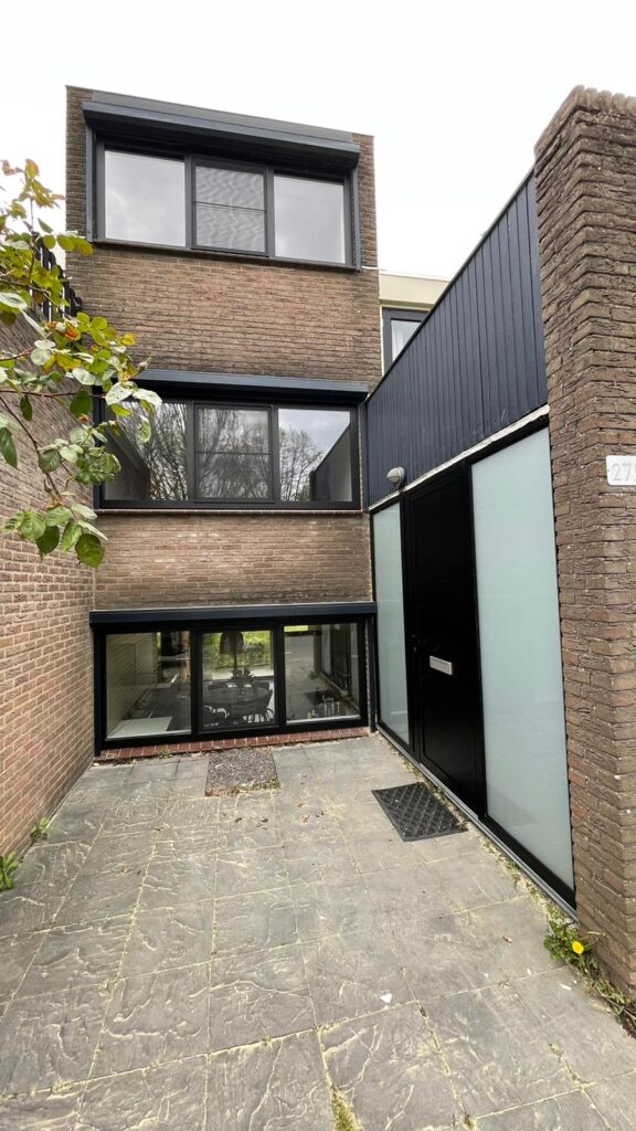Gevel met nieuw geplaatste zwarte aluminium raamkozijnen.